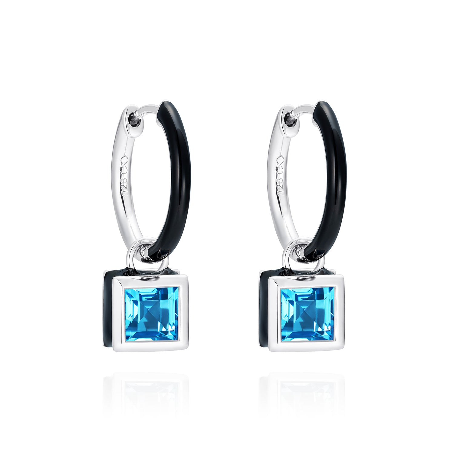 Reversible sterling silver huggie hoop earrings with square blue topaz drops, hand-applied black enamel on one side and striking silver on the other - Something Blue By Ostro